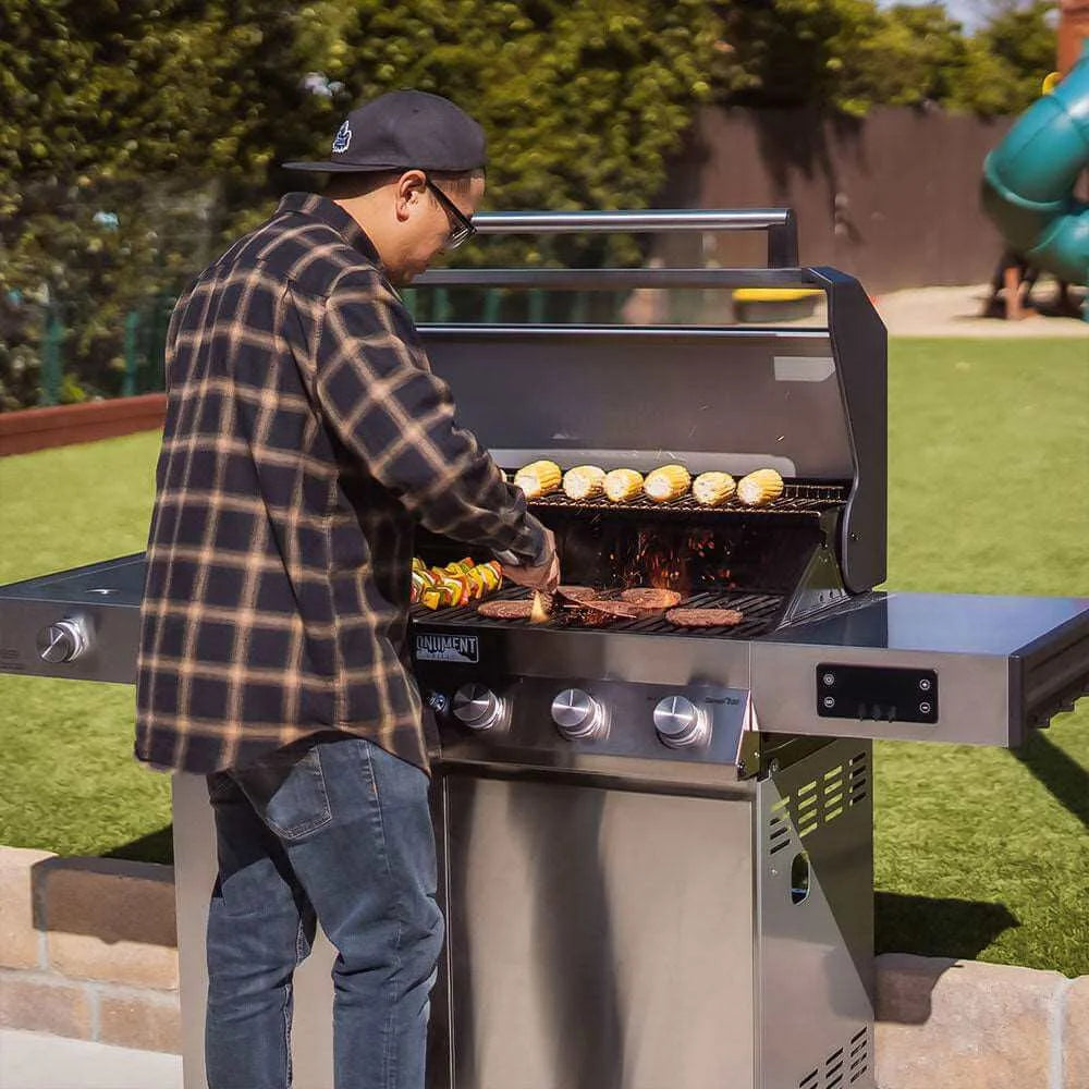 Monument Grills Denali 605 - Person grilling outdoors on a sunny day