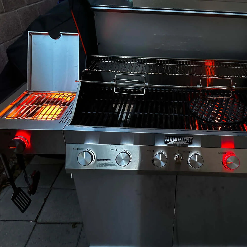 Monument Grills Denali 605 Pro -Stainless steel grill with glowing hot plates on a tiled patio