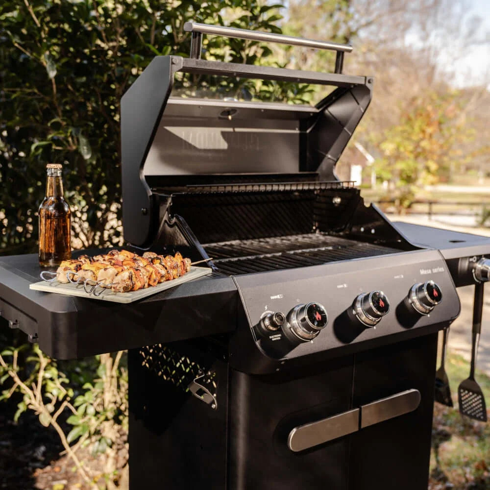 Monument Grills Mesa 325 with skewers and a bottle outdoors