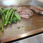 Grilled asparagus and meat on a metal tray