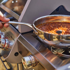 Stirring beans in a pot on a Monument Grills Mesa 415BZ stove