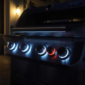 Monument Grills Mesa 415BZ with glowing control knobs in a dimly lit setting