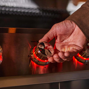 Hand adjusting a Monument Grills Mesa 415BZ knob with a close-up view of the action.