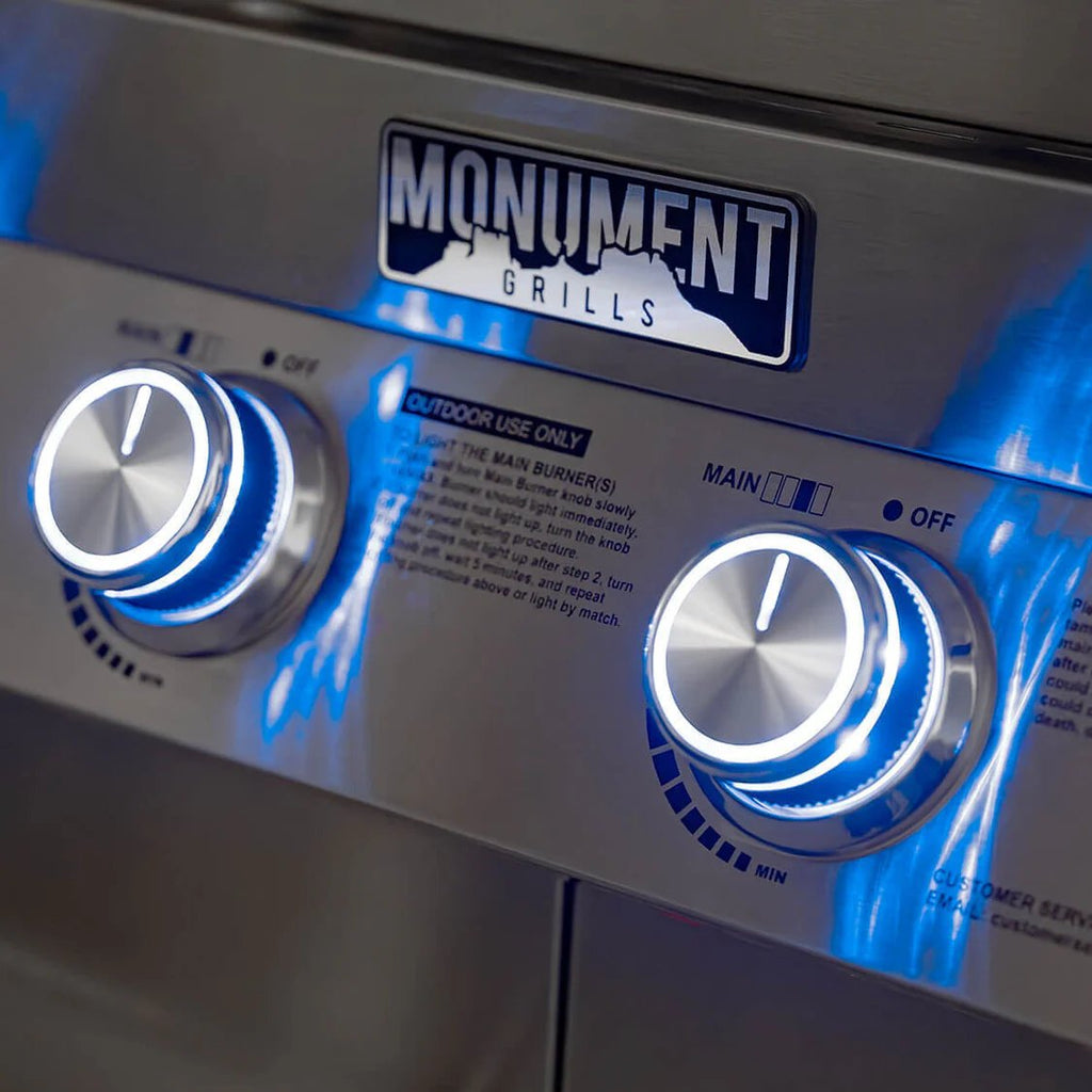 Close-up of Monument Grills grill with control knobs and branding.