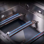 Close-up of a gas grill with lit burners on a reflective surface