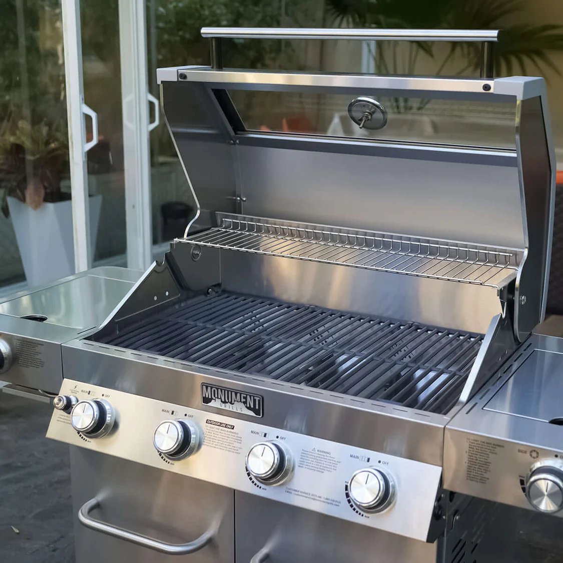 Stainless steel grill with 'Monument' branding on a patio background