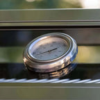 Barometer on a reflective surface with blurred green background