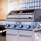 Stainless steel grill with 'Monument grill' branding in an outdoor setting