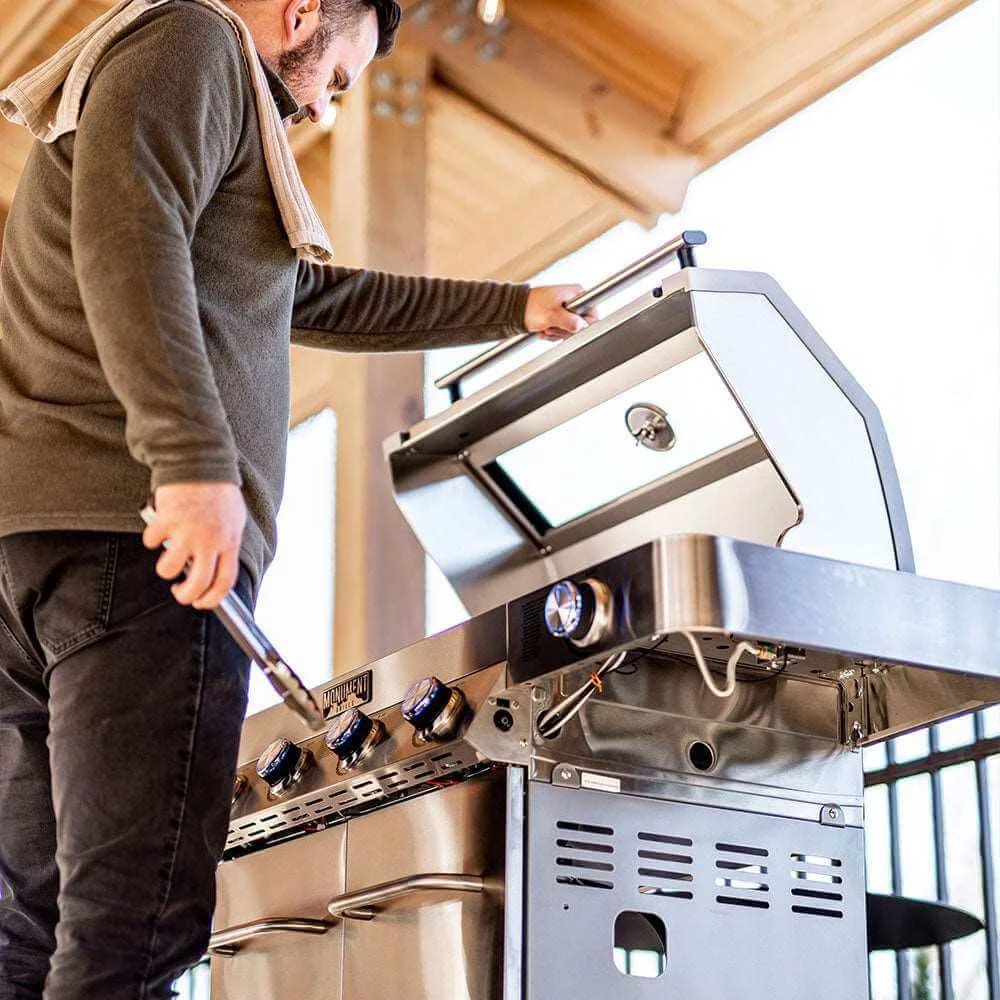 Man adjusting a stainless steel outdoor grill in an outdoor setting