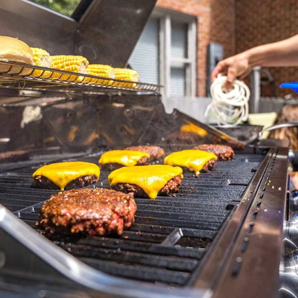 Grilling burgers with cheese and corn on a barbecue