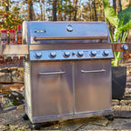 Stainless steel grill with seasoning bottles on a natural outdoor setting