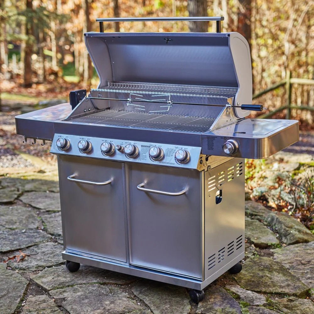 Stainless steel grill with multiple burners on a stone patio