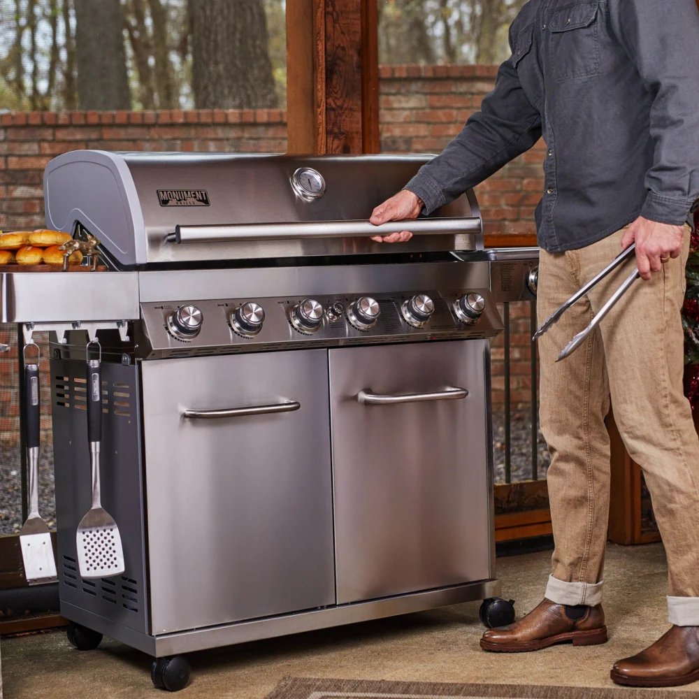 Person interacting with a large stainless steel grill outdoors