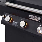 Close-up of a black grill with control knobs and 'Monument Grills' branding.
