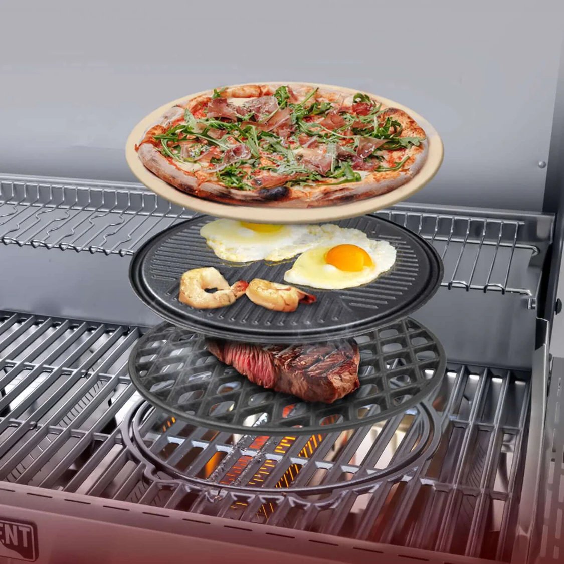 Multi-tiered grill pan with pizza, eggs, and meat on a grill