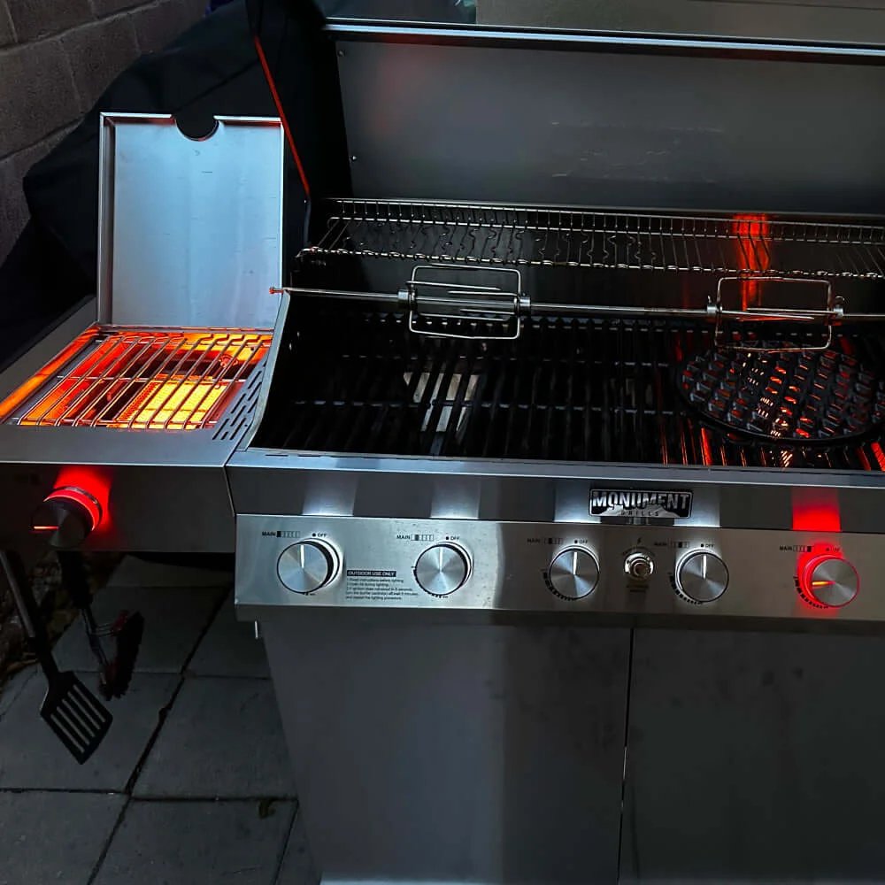 Stainless steel grill with glowing hot plates on a patio