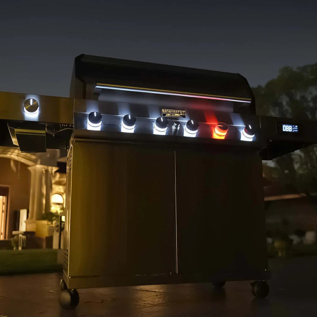 Outdoor grill with digital display and lights on a patio at night