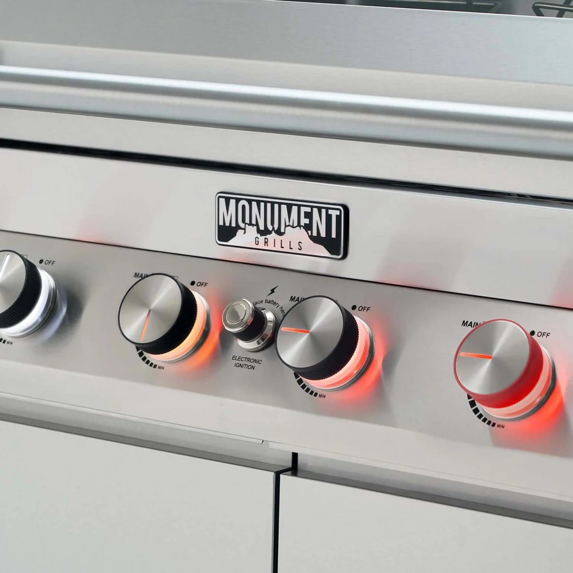 Grill with control knobs and Monument Grills logo on a white background
