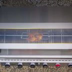 Chicken being cooked on a grill with a transparent lid