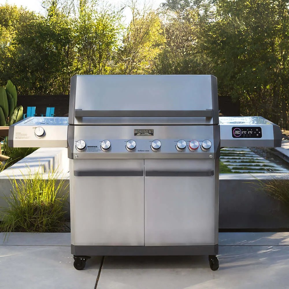 Stainless steel grill with brand logo on a patio with greenery