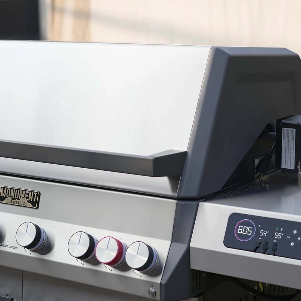 Close-up of a barbecue grill with control knobs and digital display.