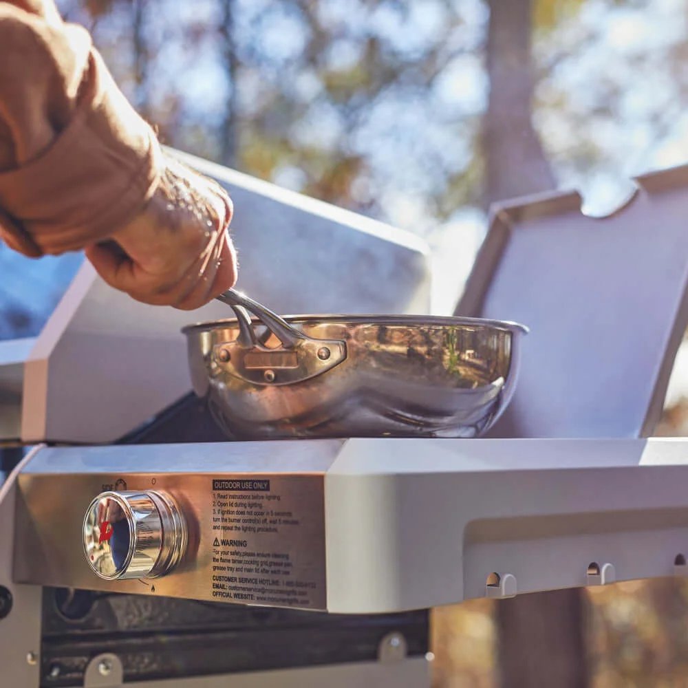 Person using a portable stove with a pot outdoors