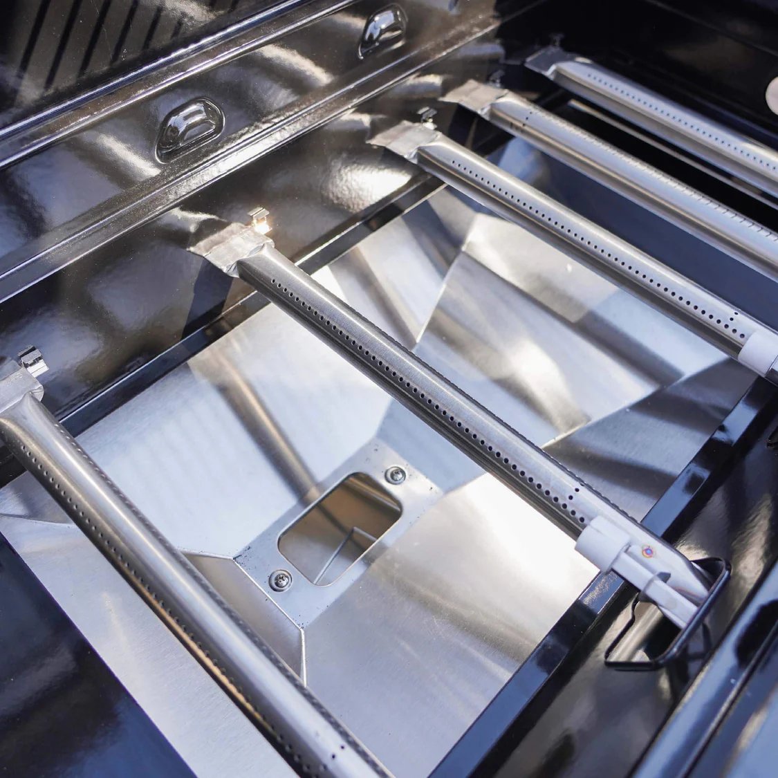 Close-up of a stainless steel grill with visible brand logo.