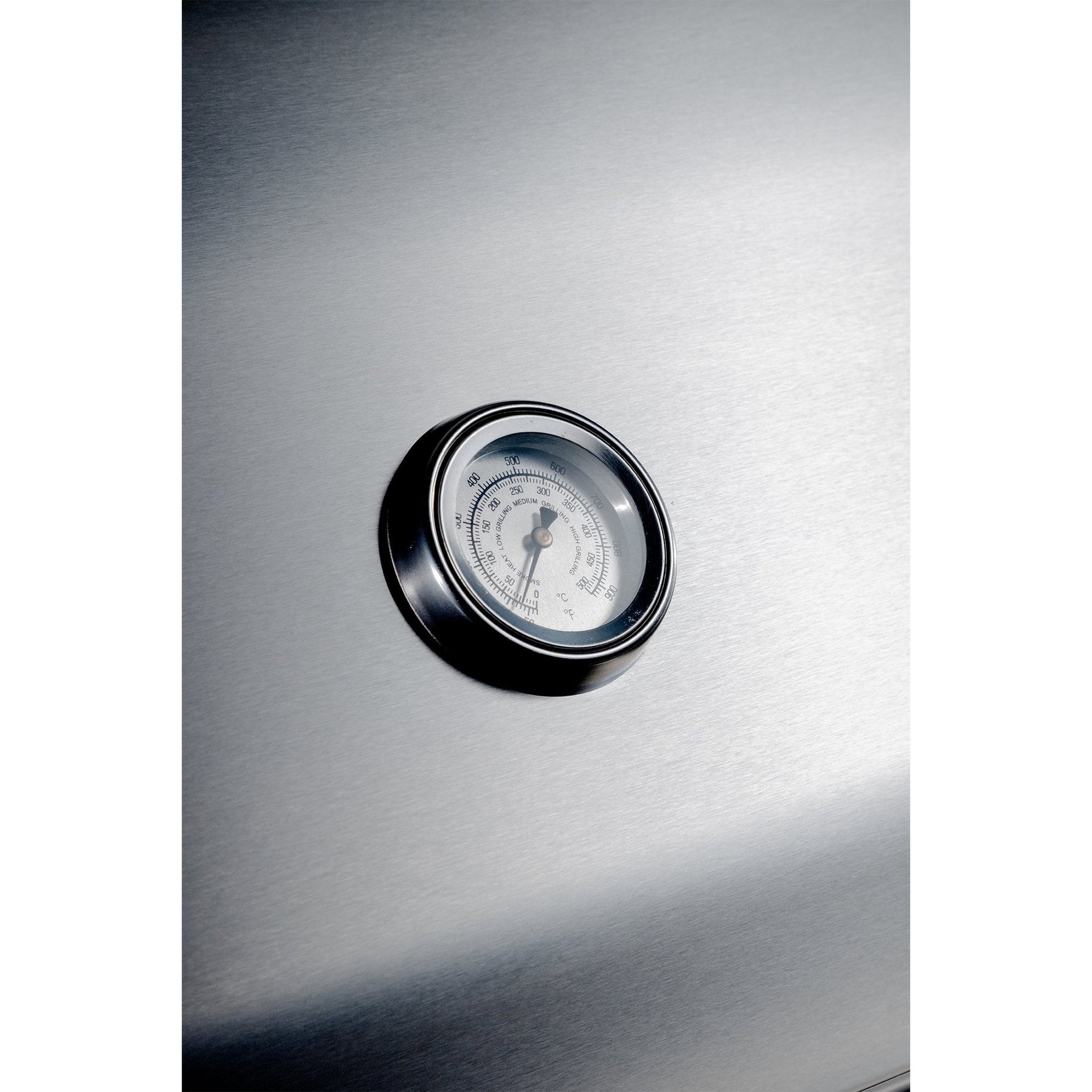 Stainless steel appliance with a round temperature gauge on a white background