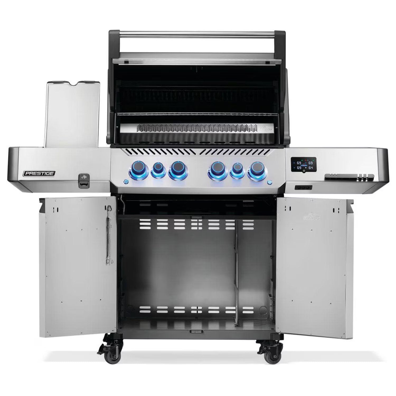Stainless steel gas grill with blue LED knobs, open lid, side shelves, and storage cabinet