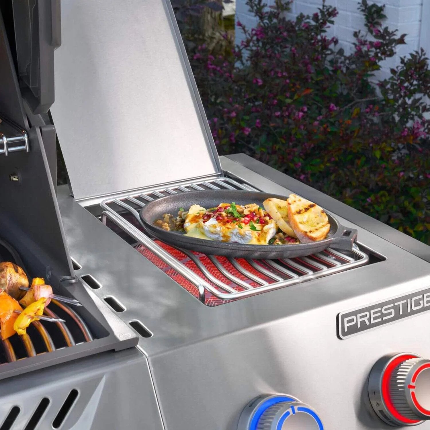 Prestige gas grill with cast iron skillet cooking brie and grilled bread outdoors
