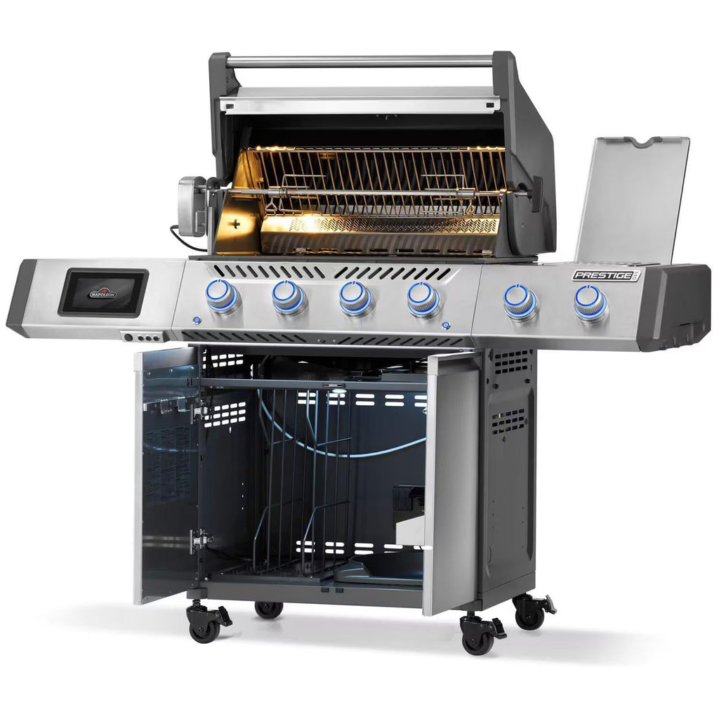 Stainless steel gas grill with rotisserie, blue control knobs, and open storage cabinet on wheels